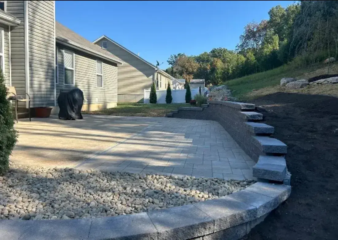 Paver patio expansion beside a curved segmental retaining wall in Valley Park, MO